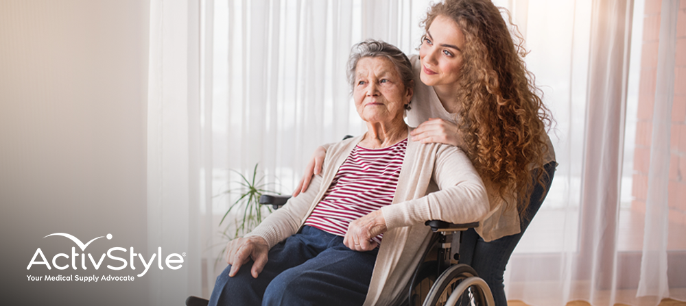 Woman smiling next to elderly woman in wheelchair