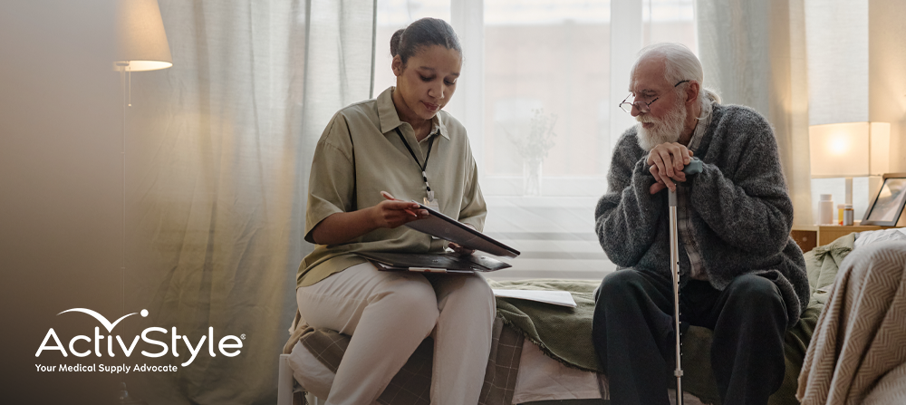 Elderly man sitting and speaking with a caregiver