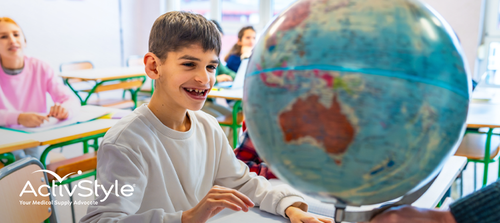 Child at school looking at globe on his desk