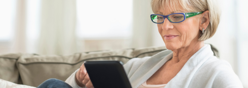Older adult woman on the couch using her tablet